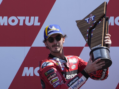 Taliansky motocyklový pretekár Francesco Bagnaia oslavuje s trofejou víťazstvo vo Veľkej cene Holandska v triede MotoGP