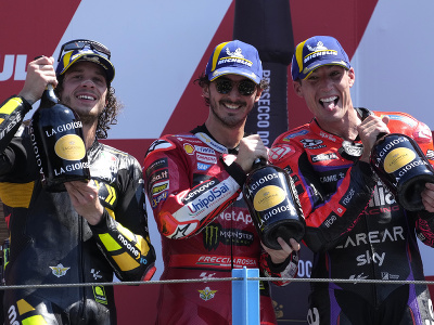 Francesco Bagnaia (v strede) oslavuje víťazstvo vo Veľkej cene Holandska v triede MotoGP, druhý skončil jeho krajan Marco Bezzecchi (vľavo), tretí Španiel Aleix Espargaro (vpravo).