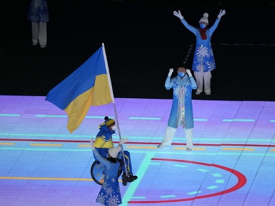 Ukrajinec Maxim Jarovyj s ukrajinskou vlajkou počas otváracieho ceremoniálu XIII. zimných paralympijských hier v Pekingu 4. marca 2022. 
