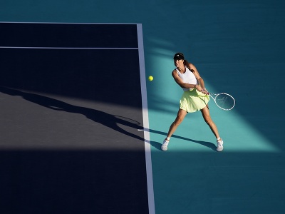Na snímke americká tenistka Danielle Collinsová odvracia loptičku Japonke Naomi Osakovej v 1. kole ženskej dvojhry na turnaji WTA v Abú Zabí