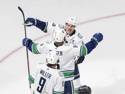 Nicolas Roy korčuľuje popri oslavujúcich hráčoch Vancouveru Canucks