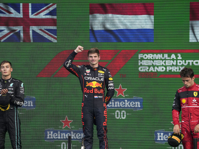 Max Verstappen z tímu Red Bull oslavuje víťazstvo na Veľkej cene Holandska. Vľavo je druhý v cieli Brit George Russell z tímu Mercedes, vpravo tretí monacký pretekár Charles Leclerc z tímu Ferrari.
