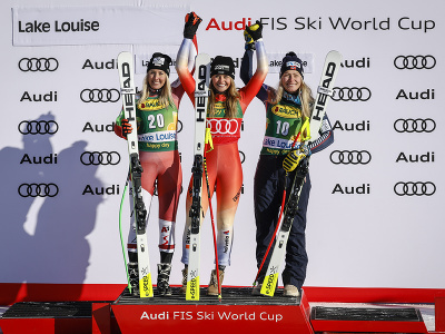 Švajčiarka Corinne Suterová oslavuje na pódiu víťazstvo v úvodnom super-G v Lake Louise, vľavo druhá Rakúšanka Cornelia Hütterová, vpravo tretia Nórka Ragnhild Mowinckelová.