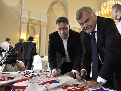 Tréner slovenskej hokejovej reprezentácie Vladimír Vůjtek a jeho asistent Peter Oremus podpisujú suveníry počas prijatia hokejovej reprezentácie na Úrade vlády
