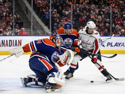 Brankár Edmontonu Stuart Skinner zasahuje pri šanci Dylana Stromea (Washington)