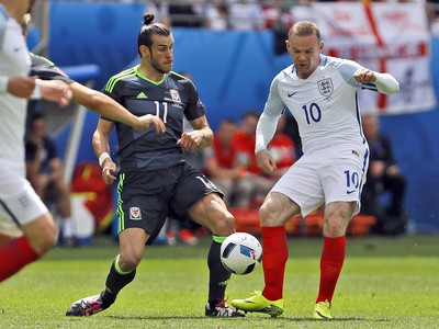 Gareth Bale (vľavo) v súboji o loptu s Waynom Rooneym