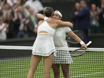 Tuniska tenistka Ons Jabeurová sa a Arina Sabalenková z Bieloruska sa objímajú po semifinále ženskej dvojhry na grandslamovom turnaji vo Wimbledone