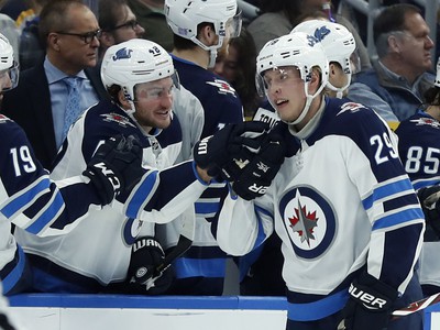 Hokejista Winnipegu Jets Patrik Laine z Fínska sa teší so spoluhráčmi po strelení gólu