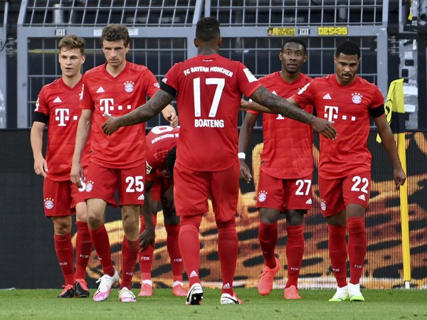 Futbalista Bayernu Mníchov Joshua Kimmich (vľavo) sa teší so spoluhráčmi po strelení gólu