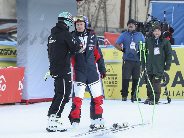 Rakúsky lyžiar Matthias Mayer (druhý zľava) sa rozpráva s členom rakúskeho tímu po prehliadke trate pred štartom štvrtkového super-G mužov  Svetového pohára v alpskom lyžovaní v talianskom stredisku Bormio