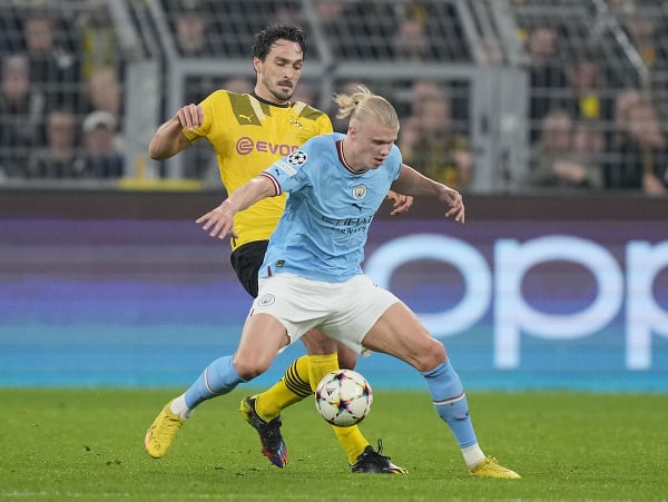 Futbalista Manchestru City Erling Haaland a hráč Borussie Dortmund Mats Hummels bojujú o loptu