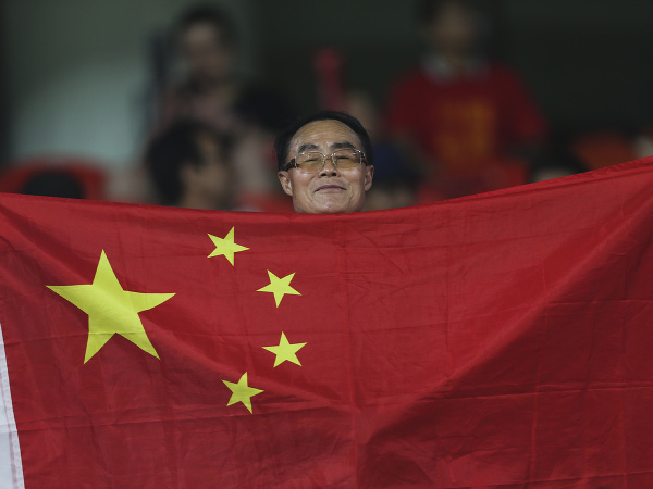  Китайский болельщик держит флаг перед четвертьфинальным матчем Кубка Азии Китай встретится с Ираном 