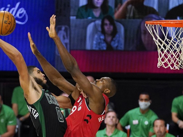 Hráč Bostonu Celtics Jayson Tatum (vľavo) strieľa na kôš cez Sergea Ibaku z Toronto Raptors
