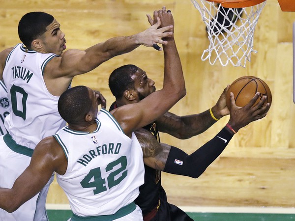 Hráči Bostonu Celtics Jayson Tatum (0) a Al Horford (42) sa pokúšajú zastaviť LeBrona Jamesa z Clevelandu Cavaliers (vpravo)