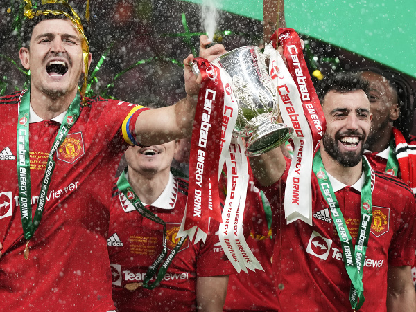 Hráči Manchesteru United Harry Maguire (vľavo) a Bruno Fernandes oslavujú s trofejou