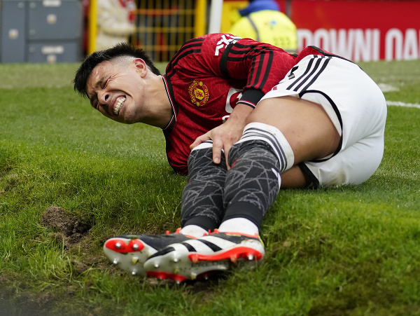 Zranený futbalista Manchestru United Lisandro Martinez leží na trávniku