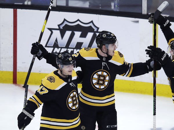 Slovenský hokejista Bostonu Bruins Peter Cehlárik (uprostred) sa s hráčmi teší po strelení gólu