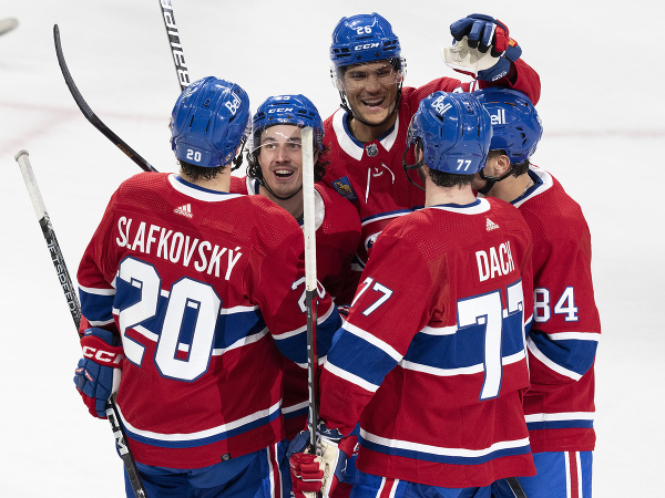 Hokejisti Montrealu oslavujú gól - v popredí Juraj Slafkovský, druhý zľava jeho spoluhráč Rafael Harvey-Pinard