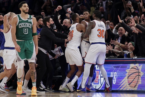 Basketbalista RJ Barrett (9) z New Yorku Knicks sa teší z víťaznej trojky si svojimi spoluhráčmi Alecom Burksom (vľavo) a Juliusom Randleom (30) v závere zápasu zámorskej NBA proti Bostonu Celtics