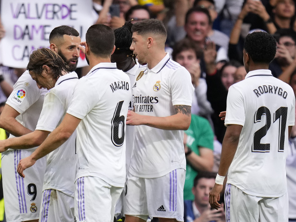 Futbalista Realu Madrid Karim Benzema (v pozadí vľavo) sa teší so spoluhráčmi po strelení gólu
