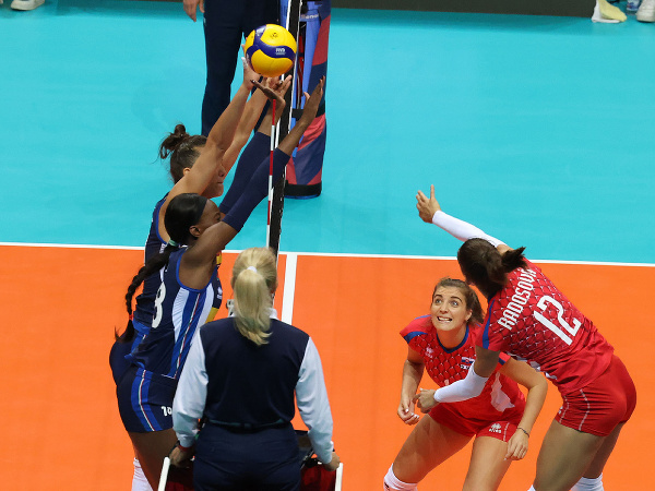 Vpravo slovenská hráčka Nikola Radosová (v červenom) smečuje v zápase C-skupiny Slovensko - Taliansko na ME vo volejbale žien