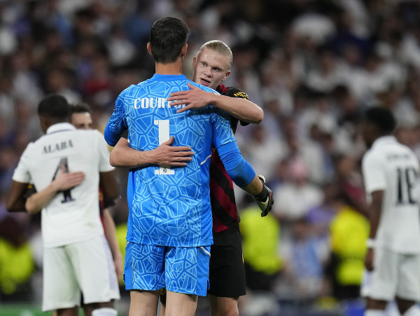 Thibaut Courtois a Erling Haaland sa objímajú po zápase Ligy majstrov medzi Realom Madrid a Manchestrom City