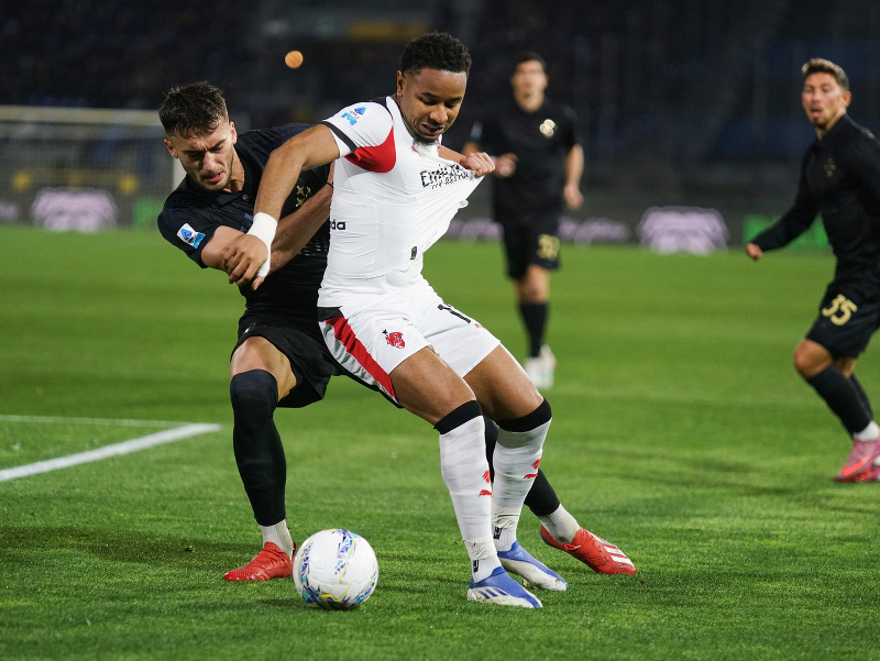 Hráč AC Milána Christopher Nkunku (uprostred) a Simone Canestrelli z SC Pisa