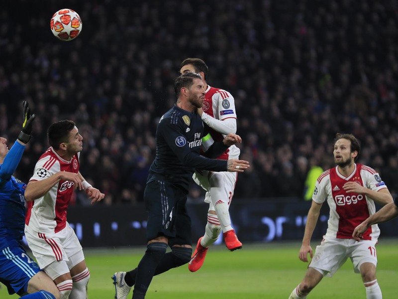 Hráč Ajaxu Nicolas Tagliafico(druhý sprava) strieľa hlavičkou gól cez Sergia Ramosa 