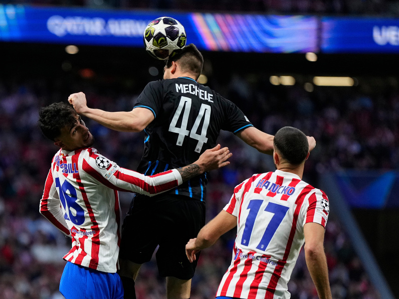 Slovenský futbalista v drese Atlética Madrid Dávid Hancko (vpravo), jeho spoluhráč Marc Pubill (vľavo) a hráč FC Bruggy Brandon Mechele (uprostred) v súboji o loptu