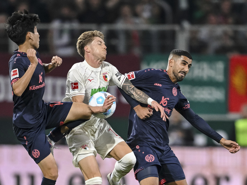 Futbalisti Mainzu Hong Hyun-seok (vľavo) a Aymen Barkok (vpravo) v súboji o loptu s Kristijanom Jakičom z Augsburgu