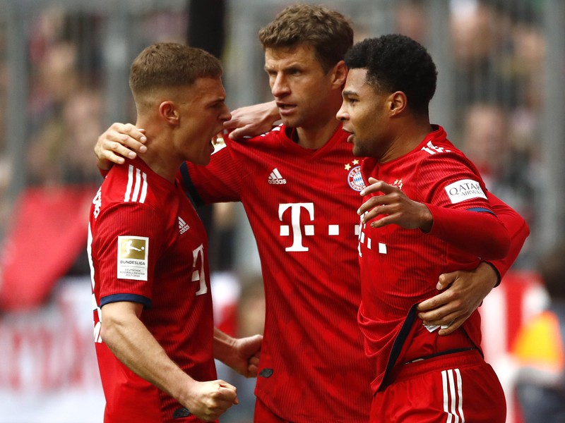 Futbalista Bayernu Mníchov Serge Gnabry (vpravo) sa teší so spoluhráčmi po strelení gólu