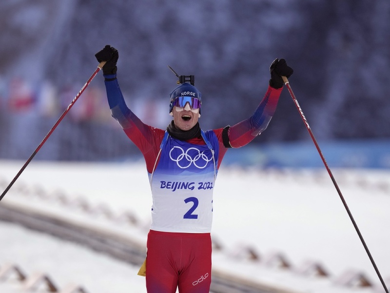 Nórsky biatlonista Johannes Thingnes Bö sa teší zo zisku zlatej medaily pri prejazde cieľom pretekov s hromadným štartom mužov na 15 km v stredisku Čang-ťia-kchou na ZOH 2022 v Pekingu