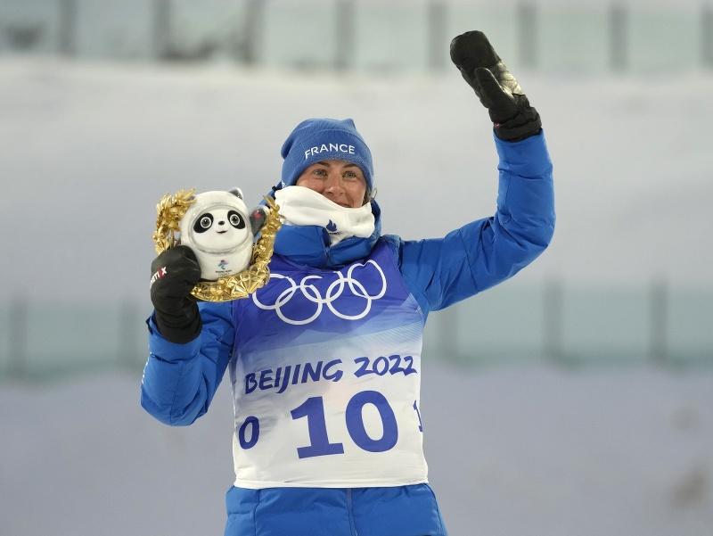 Francúzska biatlonistka Justine Braisazová-Bouchetová pózuje na pódiu po zisku zlatej medaily v pretekoch s hromadným štartom žien na 12,5 km v stredisku Čang-ťia-kchou na ZOH 2022 v Pekingu