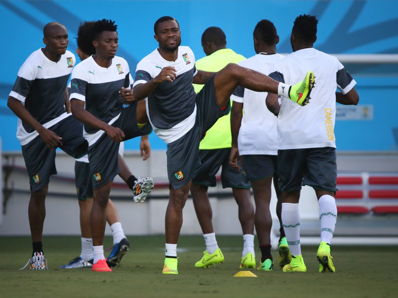 Kamerunskí futbalisti sa zahrievajú pri tréningu.