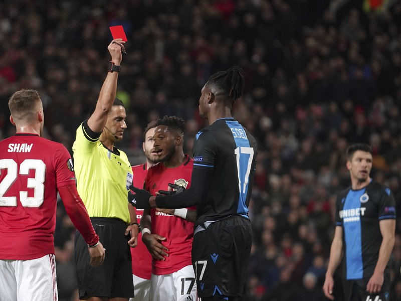 Simon Deli (druhý vpravo) z FC Bruggy dostáva červenú kartu počas odvetného zápasu šestnásťfinále Európskej ligy vo futbale Manchester United - FC Bruggy