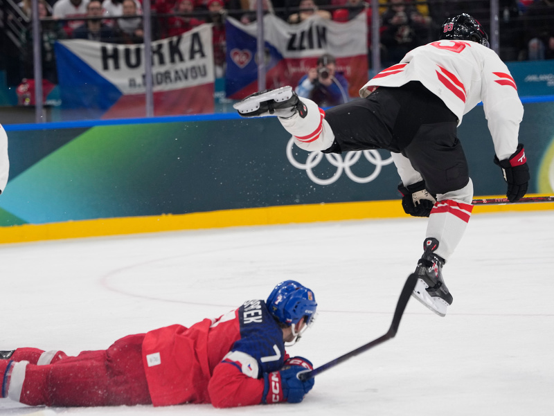 Kanadský hokejista Mitch Marner (vpravo) a hráč Česka David Špaček (uprostred) bojujú o puk