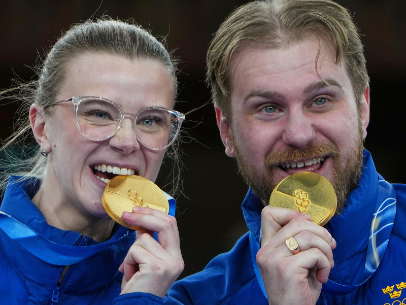 Švédski curlingoví reprezentanti a súrodenci Isabella Wranová a Rasmus Wrana pózujú so zlatými medailami po finálovom zápase miešaných dvojíc na ZOH 2026