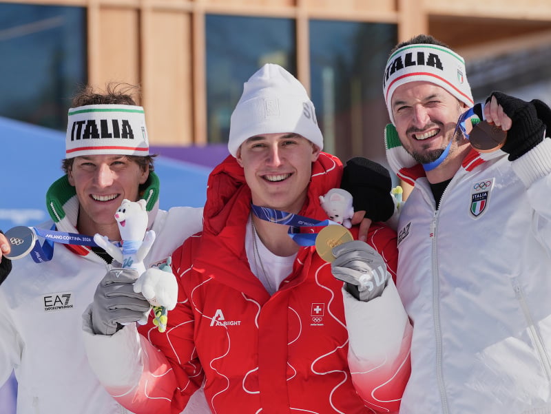 Švajčiar Franjo von Allmen sa raduje zo zisku zlatej medaily v mužskom zjazde na zimných olympijských hrách v talianskom Bormiu, druhý Talian Giovanni Franzoni (vľavo) a tretí Dominik Paris (vpravo).