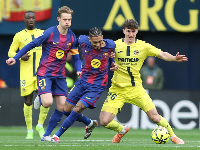 Raphinha z Barcelony (v strede) súperí o loptu s Pauom Navarrom z Villarrealu (vpravo) počas zápasu španielskej futbalovej La Ligy medzi Villarrealom a Barcelonou vo Villarreale