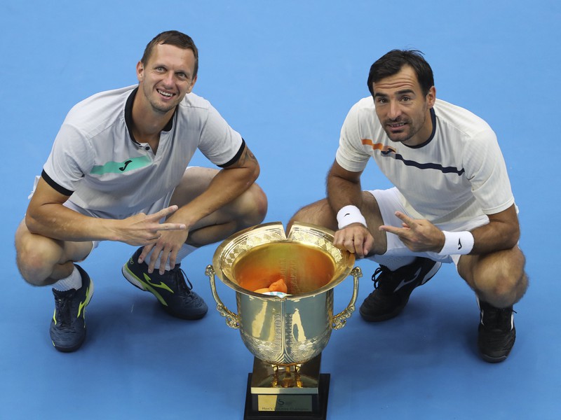 Slovensko-chorvátsky deblový pár Filip Polášek (vľavo) a Ivan Dodig pózujú s trofejou 