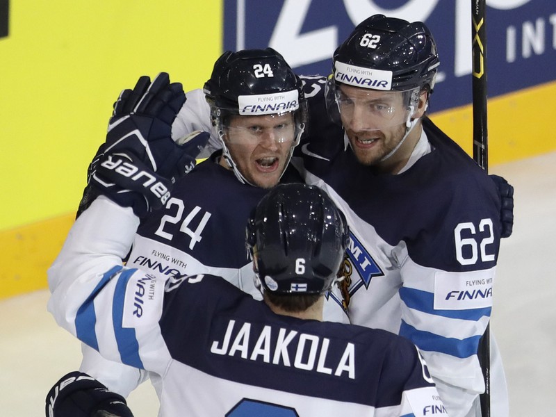Fínsky hráč Jani Lajunen (vľavo) oslavuje so spoluhráčmi Oskarom Osalom (vpravo) a Topim Jaakolom (vpredu) úvodný gól