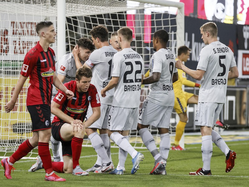 Hráč Leverkusenu Kai Havertz (vľavo v pozadí) oslavuje so spoluhráčmi úvodný gól do bránky Freiburgu