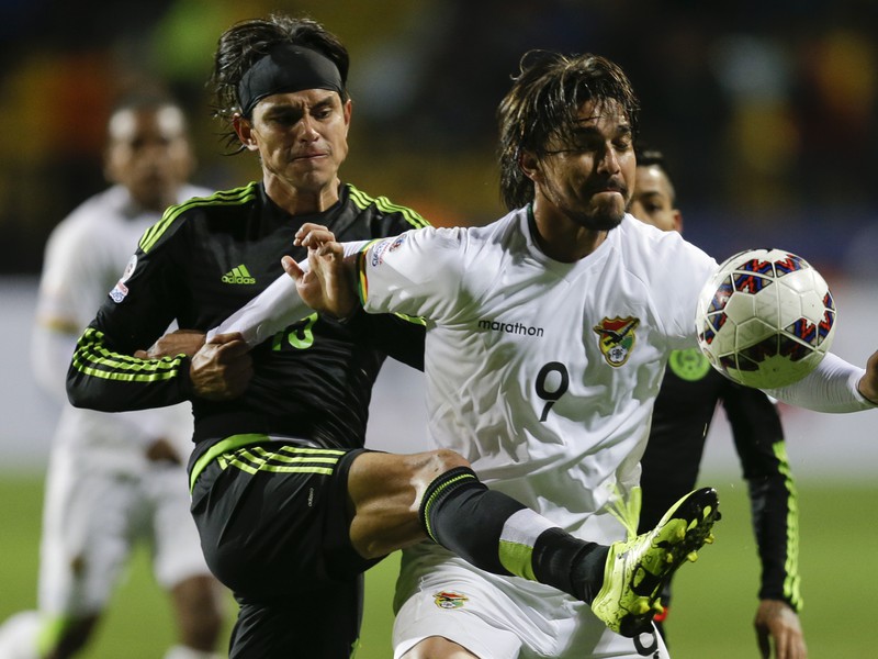 Gerardo Flores (vľavo) bojuje o loptu s hráčom Bolívie Marcelom Morenom