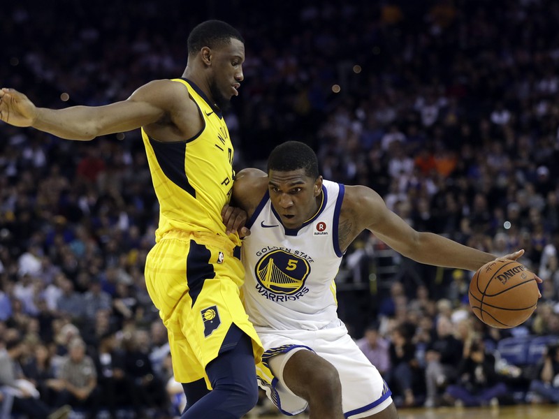 Kevon Looney (vpravo) sa snaží prejsť cez Thaddeusa Younga