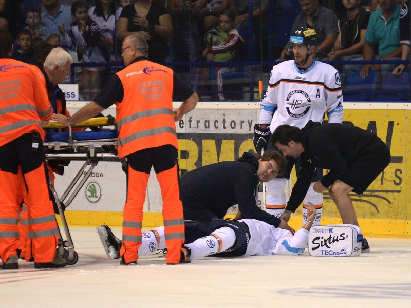 Na snímke vpravo na ľade leží zranený hokejista Košíc Lukáš Matejka, ktorého záchranári prepravujú do nemocnice