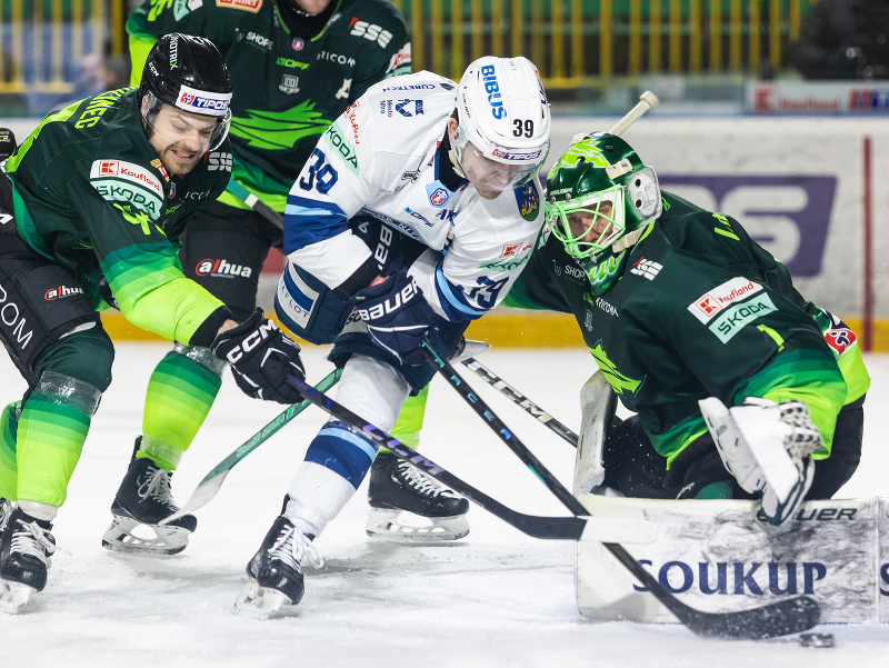 Zľava v súboji o puk Daniel Gachulinec (Žilina), Jakub Lacka (Nitra) a brankár Connor LaCouvée (Žilina)