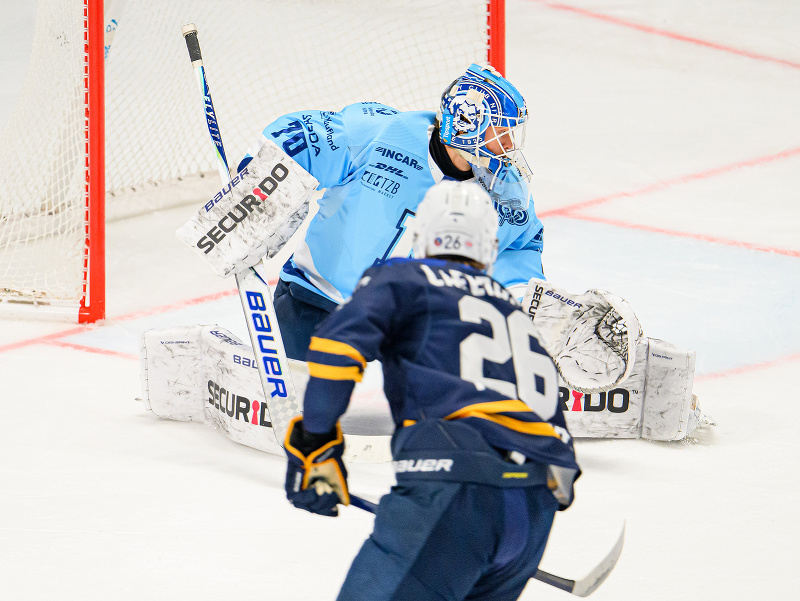 Brankár Jasper Patrikainen z HK Nitra a strelec gólu Mathias Laferriere