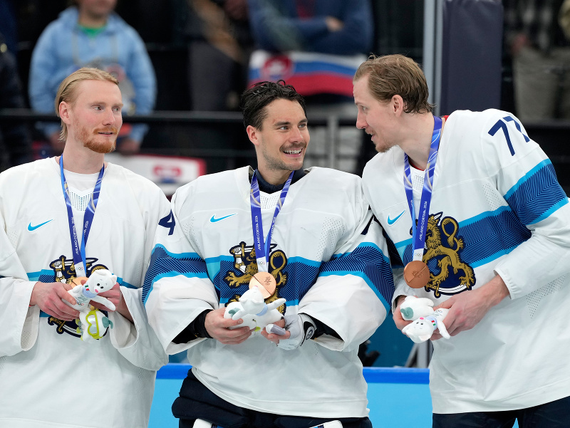 Fínski hokejisti sa tešia po zisku bronzu na ZOH 2026 - zľava Joel Armia, Juuse Saros a Niko Mikkola
