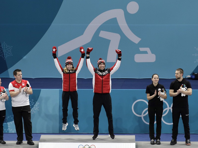 Kanadskí reprezentanti Kaitlyn Lawesová (tretia zľava) a John Morris (tretí sprava) sa tešia po zisku zlatej olympijskej medaily v curlingu miešaných dvojíc na ZOH v Pjongčangu