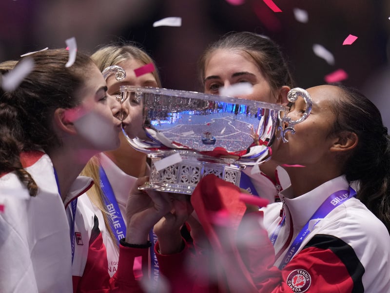 Kanadská tenistka Leylah Fernandezová (vpravo) bozkáva trofej s členkami svojho tímu po jej víťazstve nad Taliankou Jasmine Paoliniovou vo finále na finálovom turnaji Pohára Billie-Jean Kingovej